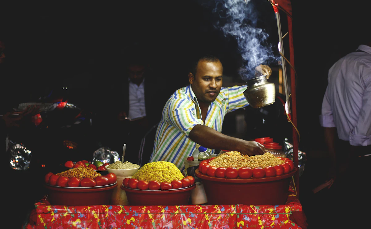 woman in blue and white stripe shirt holding red plastic tray with strawberries — The roaming chaat cart