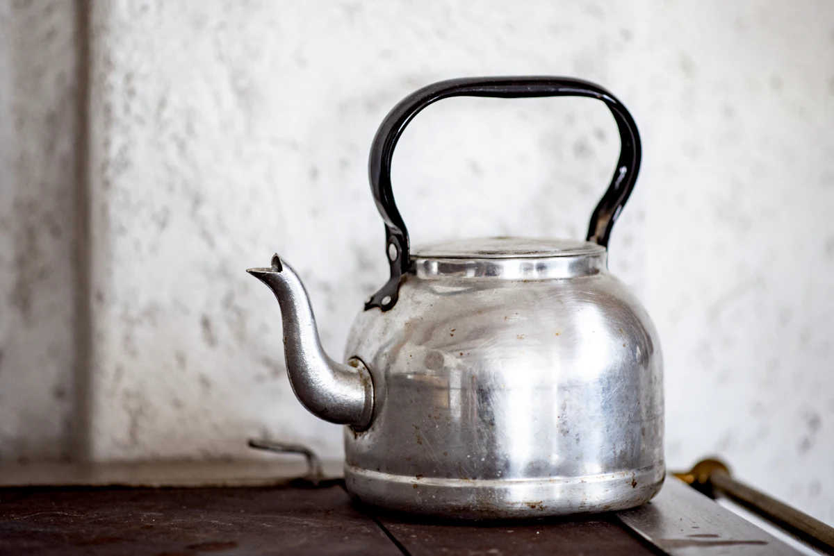 stainless steel kettle on brown wooden table — The kulhad chai and filter coffee cart