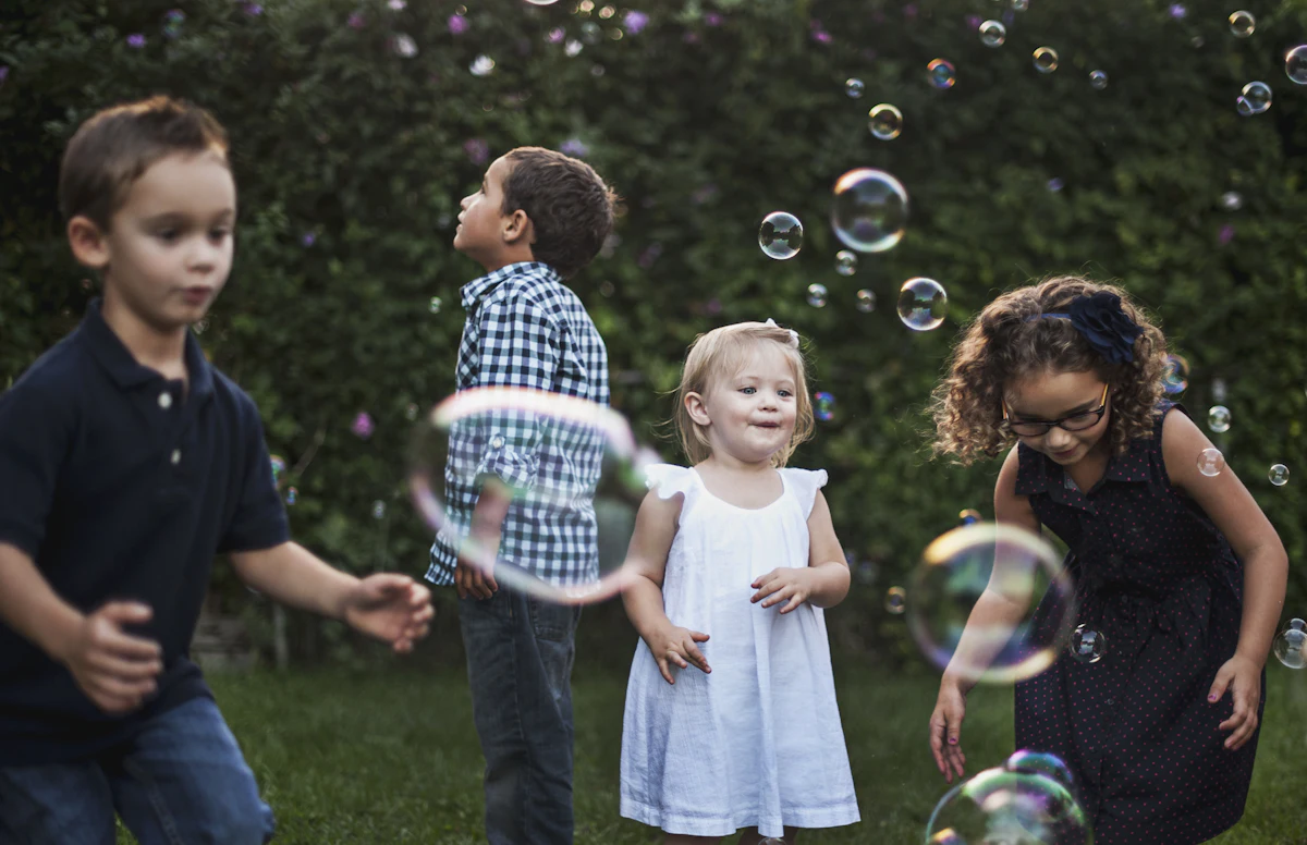 Four children playing with floating bubbles in a green garden — A kids’ corner that actually works