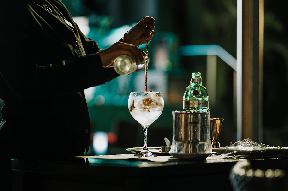 a person pouring a drink into a glass — The mocktail mixology bar