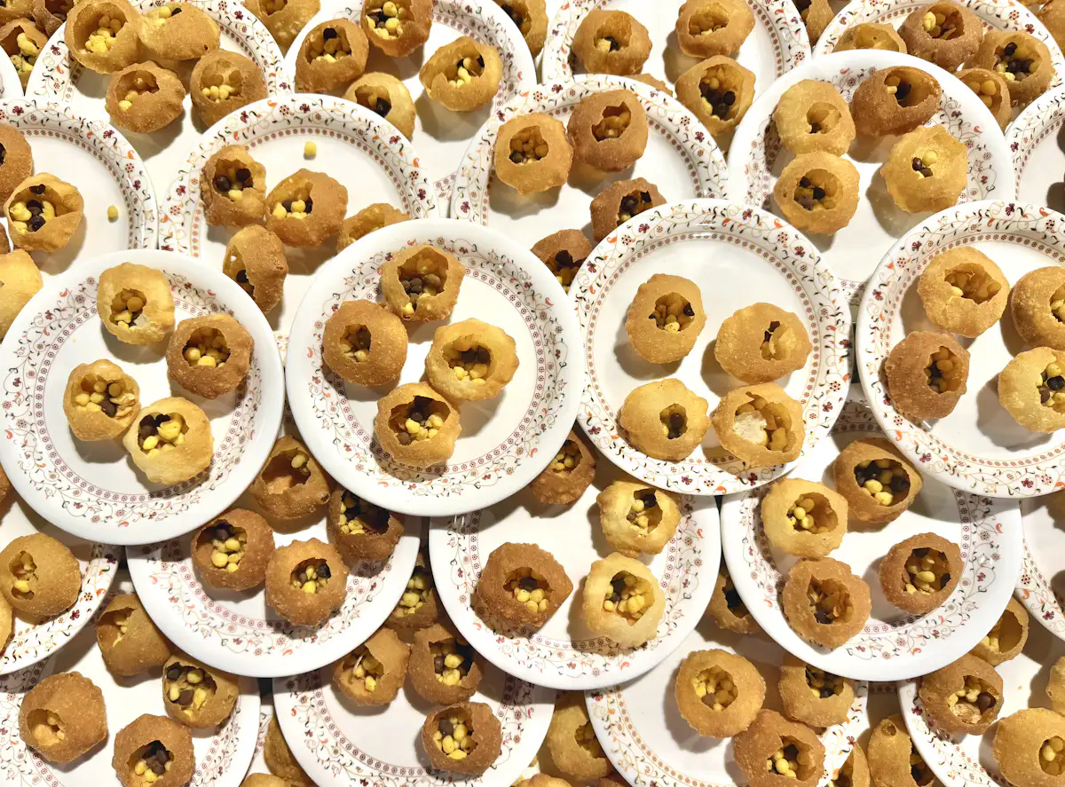 Many pani puri snacks on white paper plates — The pani puri shot bar
