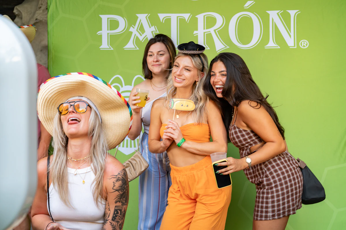 Friends pose happily in a photo booth with props — The 360° spinner booth