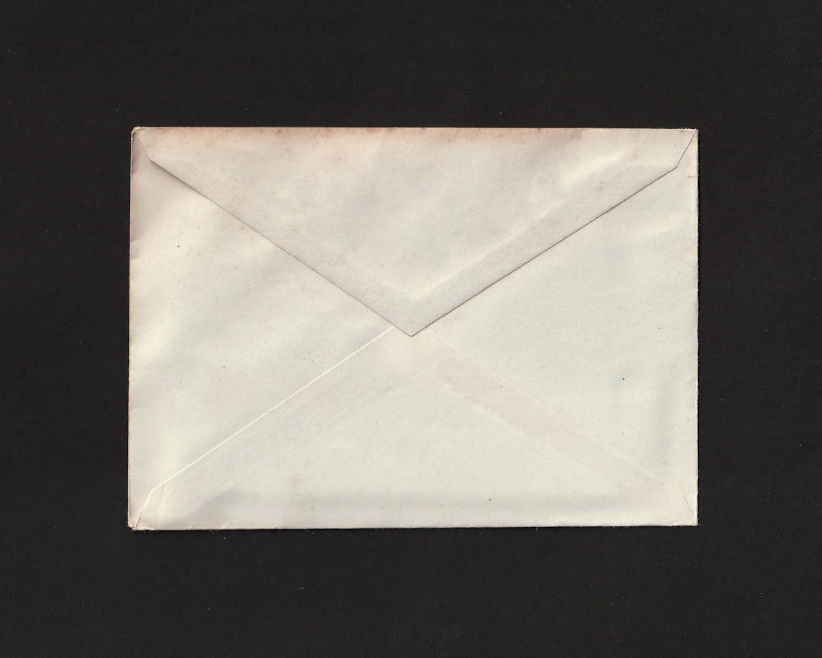 A white envelope on a black background — Room-drop notes, written by hand