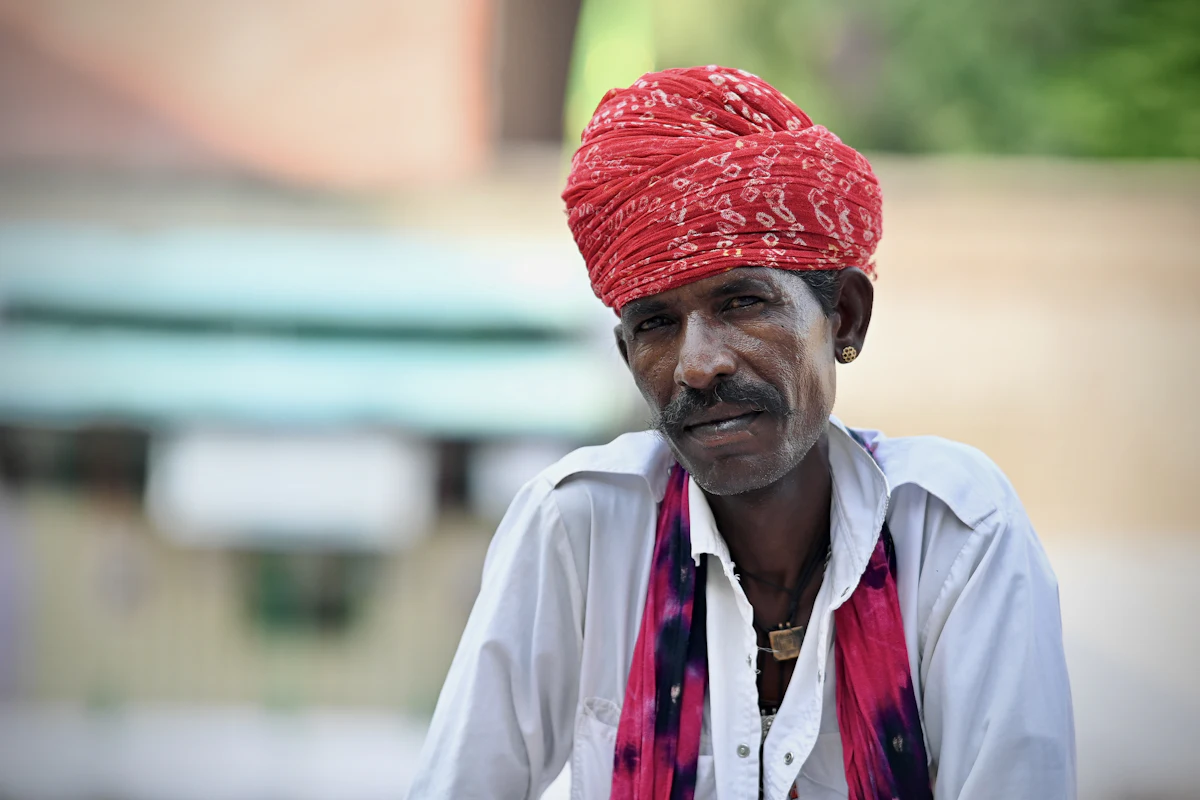 a man with a red turban on his head — A safa and turban tying station
