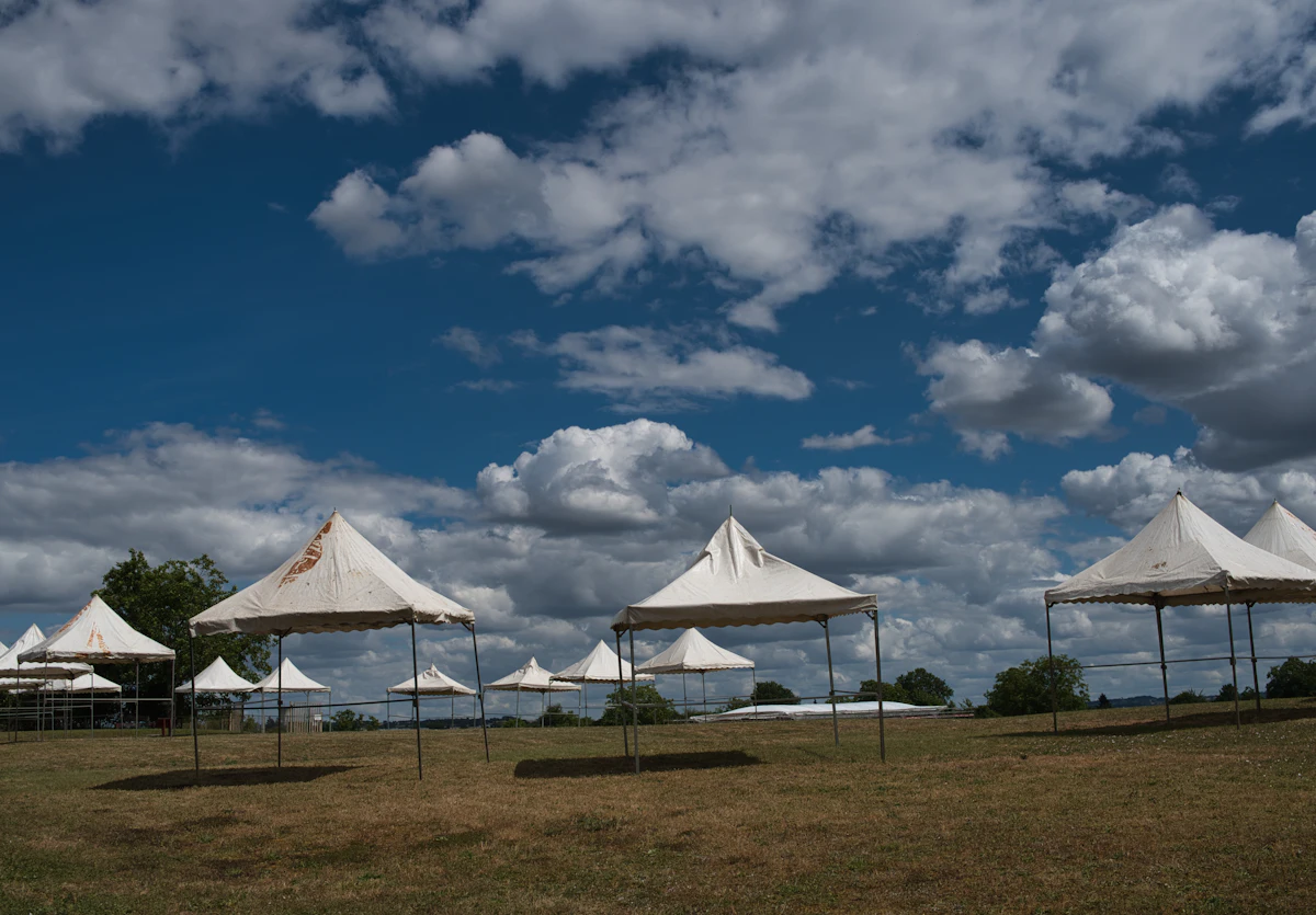 White tents in a dry field under a cloudy sky — Choosing a tent that is not just a roof