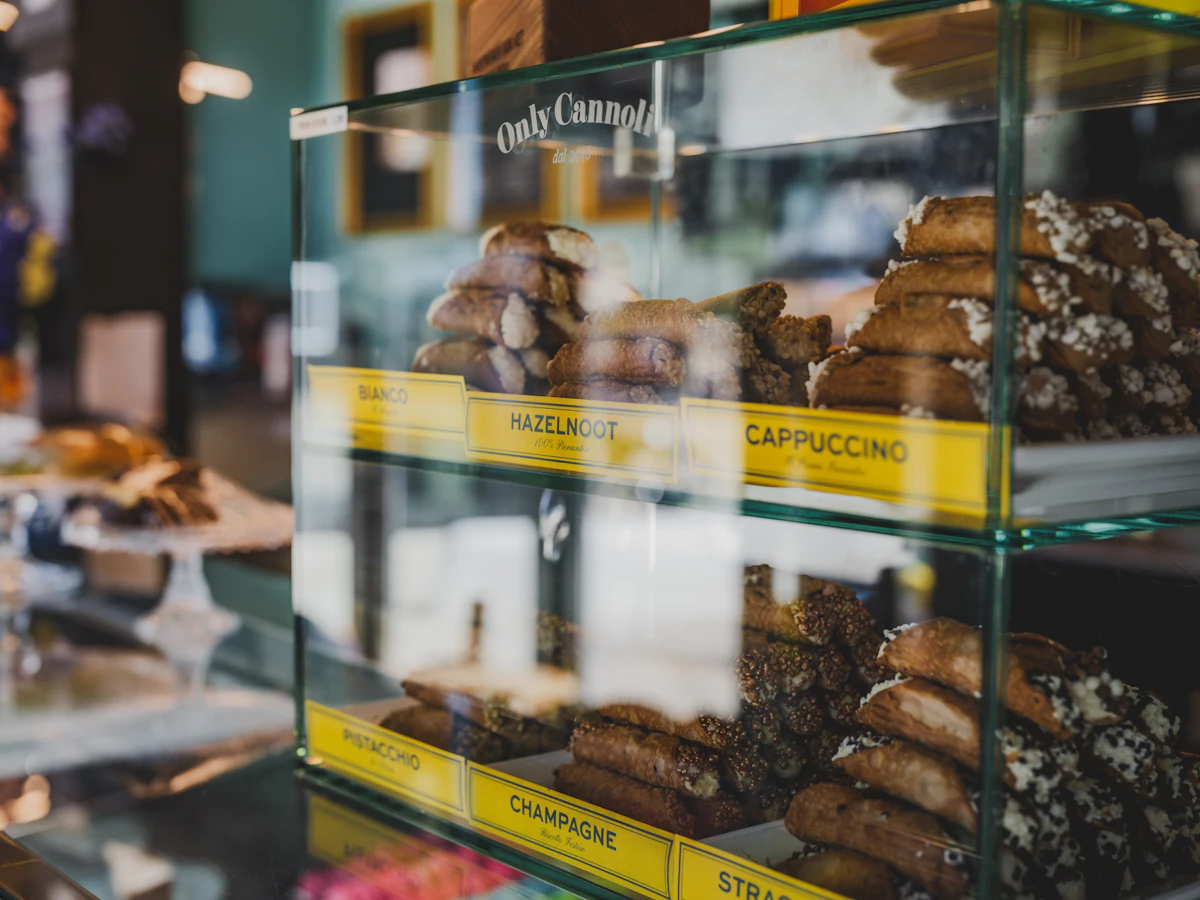 Pastries displayed in a bakery display case — The walking cannoli station
