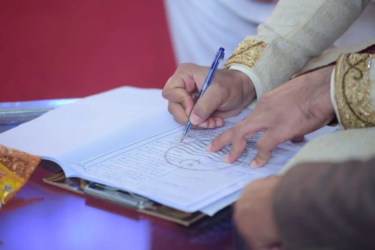 A groom signing the marriage contract at a nikah ceremony